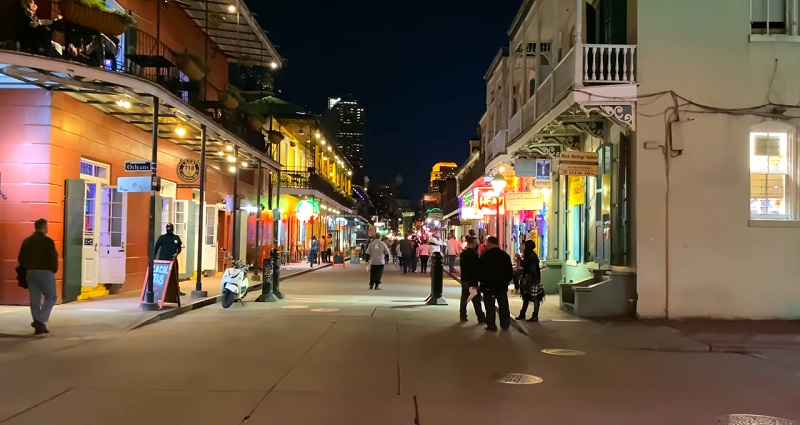 Lively nightlife and glowing signs along Bourbon Street, representing vibrant New Orleans culture