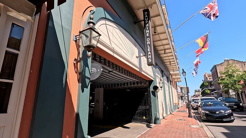 Entrance of the Dauphine Orleans Hotel with flags along a historic New Orleans street
