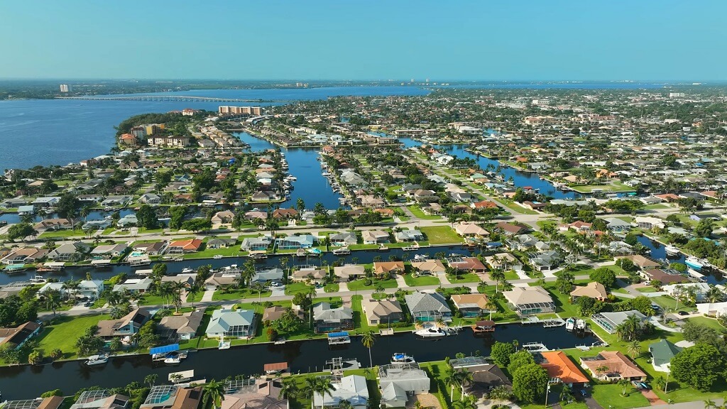 Suburban waterfront neighborhoods in Cape Coral, Florida, with residential canals leading to the Gulf