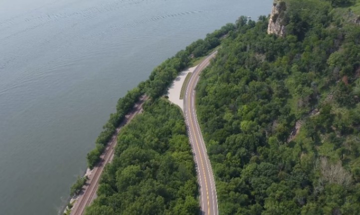 Aerial view of the winding Great River Road surrounded by lush green forest