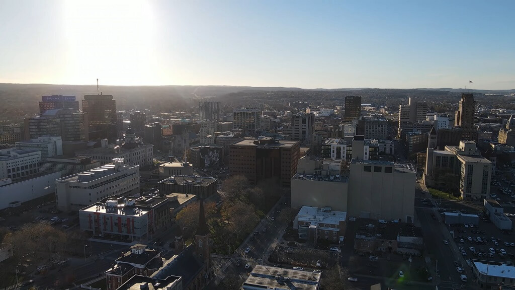 Evening skyline of Syracuse, New York, with tall downtown buildings under a fading sunset